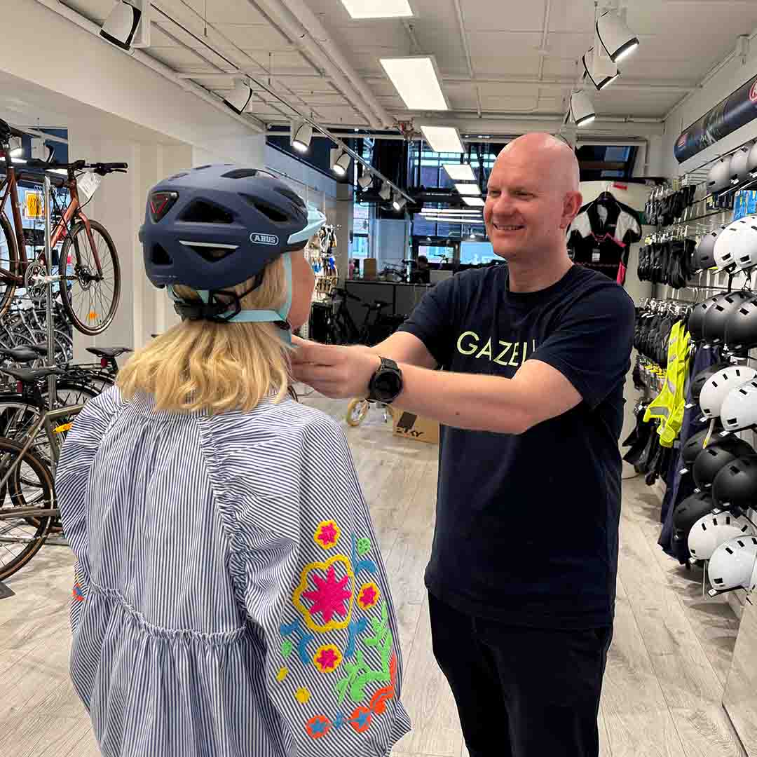 Kunde prøver en gul cykelhjelm hos PP Cykler i Amager Centret. 